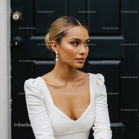 Elegant woman in white dress posing by black door