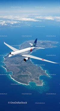 Passenger Airplane Flying Over Coastal Island in Bright Blue Sky