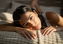Young Woman Relaxing Lying on Bed in Cozy Bedroom