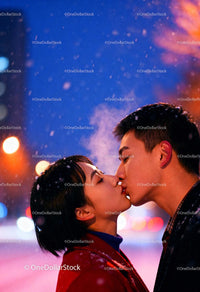 Couple Sharing a Tender Kiss on a Snowy Evening