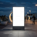 Illuminated blank billboard on urban pedestrian bridge at dusk