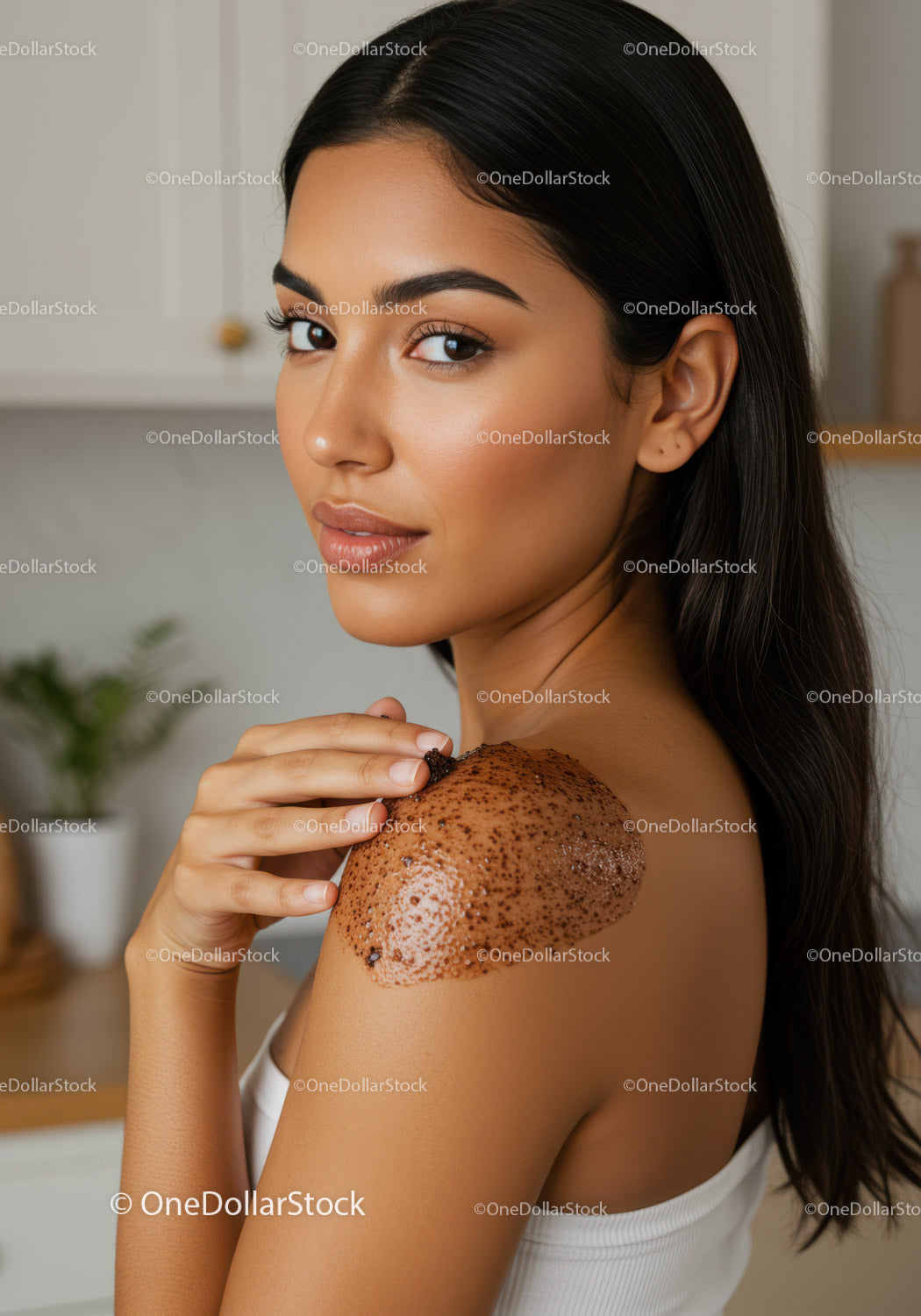 Młoda kobieta w białym topie nakładająca peeling czekoladowy