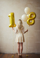 Young woman celebrating eighteenth birthday with balloons