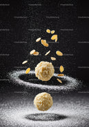 Almond treats with powdered sugar against dark background