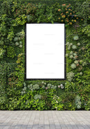 Green vertical garden with blank frame on urban wall