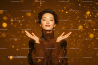 Elegant Woman in Gold Sparkling Dress Amid Festive Confetti