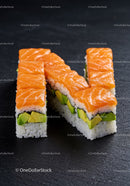Fresh salmon avocado sushi rolls on dark slate plate