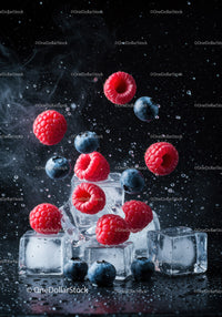 Fresh raspberries and blueberries with ice cubes splash