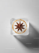 Star Anise Embedded in Clear Ice Cube on White Surface