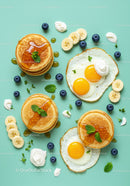 Fresh breakfast with pancakes fried eggs and fruits