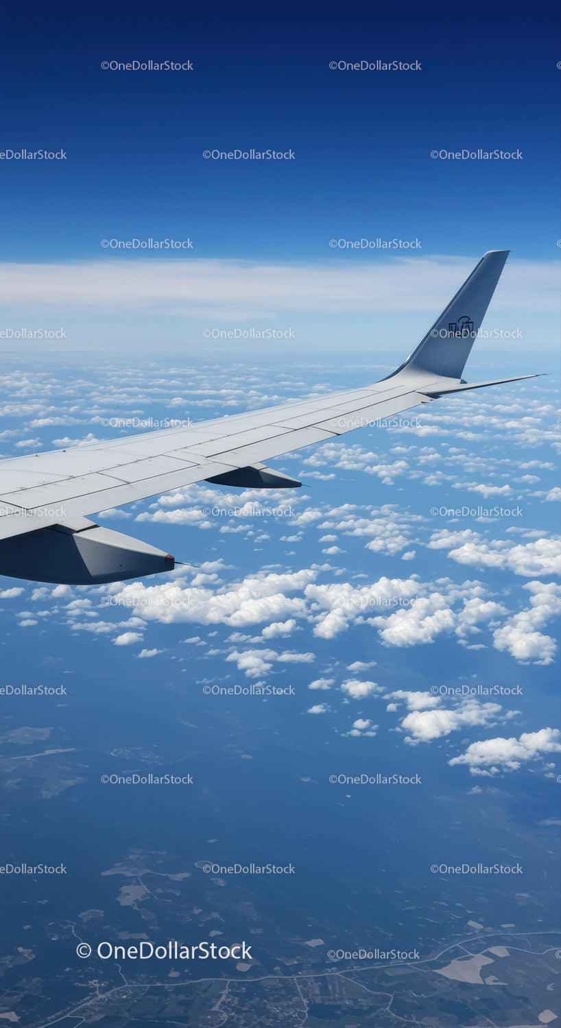 Aerial View of Passenger Airplane Wing Against Blue Sky and Clouds