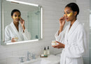 Woman Applying Face Cream with Under-Eye Patches in Bathroom