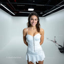 Smiling Young Woman in White Dress in Modern Studio