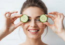 Young Woman Holding Cucumber Slices Over Eyes for Skincare and Beauty