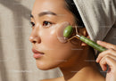 Close-Up of Woman Using Jade Roller for Facial Skincare and Relaxation