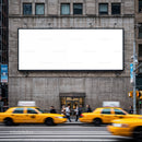 Busy city street with yellow taxis and blank billboard