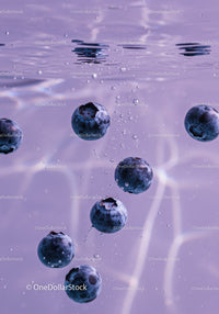 Fresh blueberries sinking in clear water with bubbles