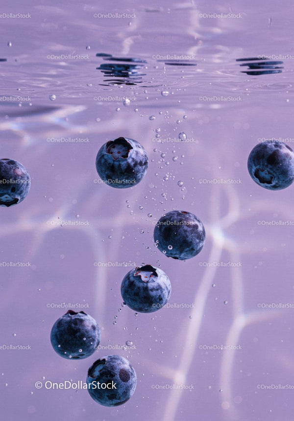 Fresh blueberries sinking in clear water with bubbles
