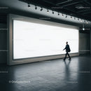 Businessman walking past large illuminated advertisement panel