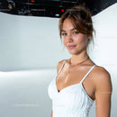 Confident Young Woman Smiling in White Dress with Elegant Jewelry