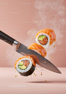 Fresh salmon sushi rolls with avocado being sliced by knife