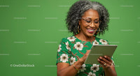 Smiling Woman Using a Digital Tablet in a Floral Dress
