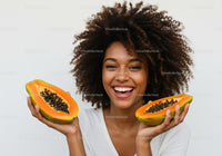 Smiling Woman Holding Fresh Ripe Papayas in Both Hands