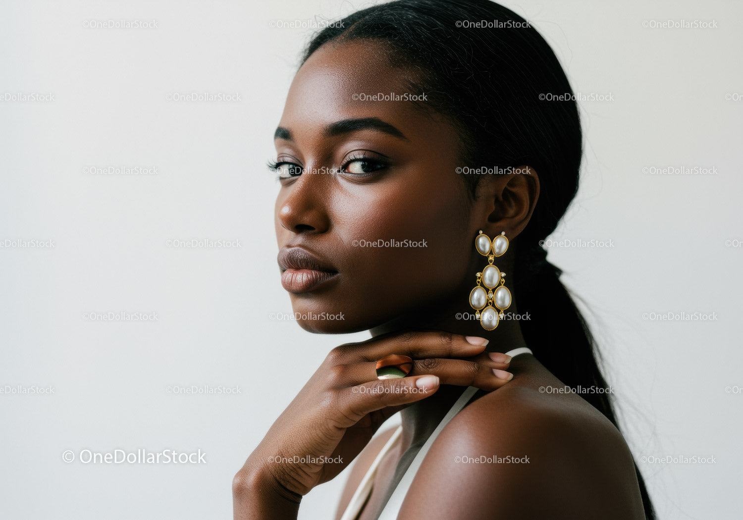 Elegant Black Woman Wearing Statement Pearl Earrings and Sleek Hair