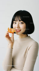 Smiling Woman Holding a Citrus Slice in Bright Modern Portrait