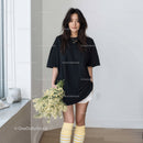 Fashionable Young Woman in Black T-Shirt and Yellow Socks Holding Flowers