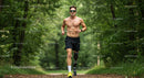 Male Runner with Prosthetic Leg Running Through Foggy Forest Trail