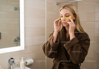 Relaxing Woman Applying Under Eye Patches in Bathroom