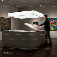 Man Reviewing Colorful Artwork in Modern Gallery Space