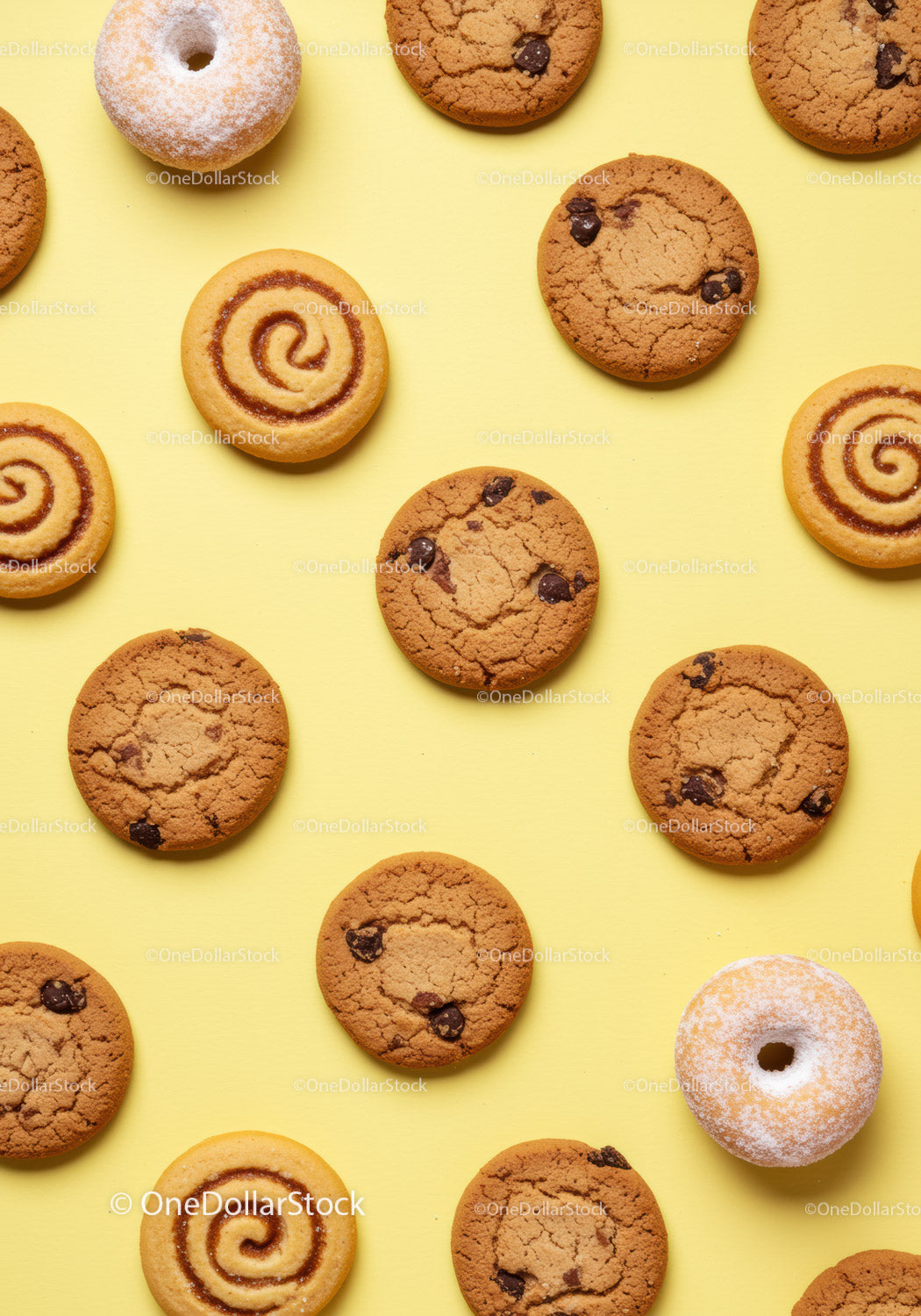 Assortment of cookies and powdered donuts on yellow