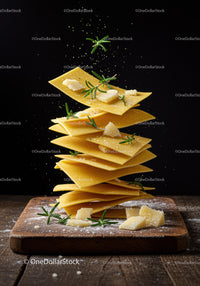Stacked fresh pasta sheets with rosemary and parmesan