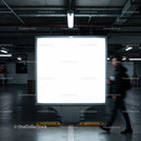 Blank illuminated billboard in dim underground parking garage