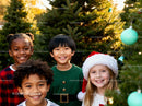 Smiling diverse children enjoying Christmas tree outing