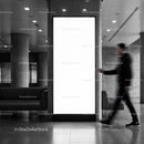 Blurred man walking past blank urban advertising display