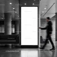 Blurred man walking past blank urban advertising display