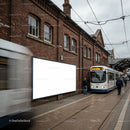 Urban tram stop with blank billboard on brick wall