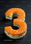 Fresh salmon sushi rolls with avocado on black slate