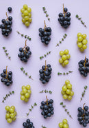 Green and Black Grapes with Fresh Herb Sprigs on Lilac