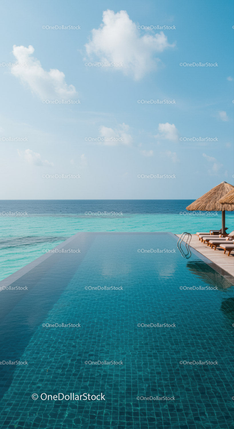 Serene Oceanfront Infinity Pool with Wooden Deck and Straw Umbrella
