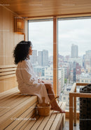 Woman Relaxing in Sauna with Cityscape View in Modern Wellness Center