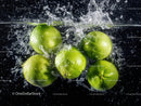 Fresh Green Limes Splashing Into Water Creating Dynamic Refreshing Scene