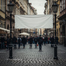 Empty white banner hanging above cobblestone street crowd