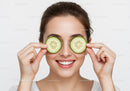 Smiling Woman with Cucumber Slices Over Eyes for Refreshing Skin Care