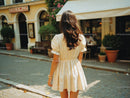 Stylish Woman in Beige Summer Dress Walking on City Street
