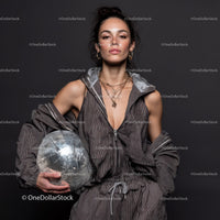 Stylish Woman in Metallic Outfit Holding Disco Ball for Modern Fashion