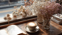 Dried Flowers in Amber Jar with Coffee and Open Book